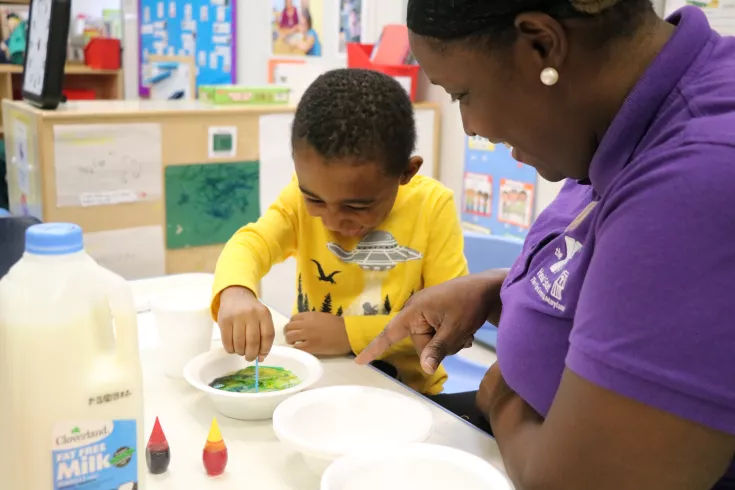 Y teacher working with happy preschooler